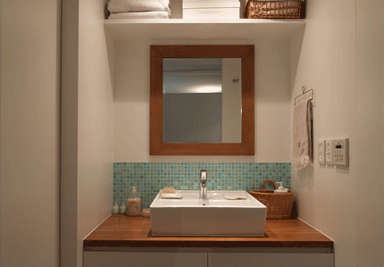 木枠の鏡とタイルがオシャレな洗面台。「お風呂もタイルにしたかったんですけど断念」