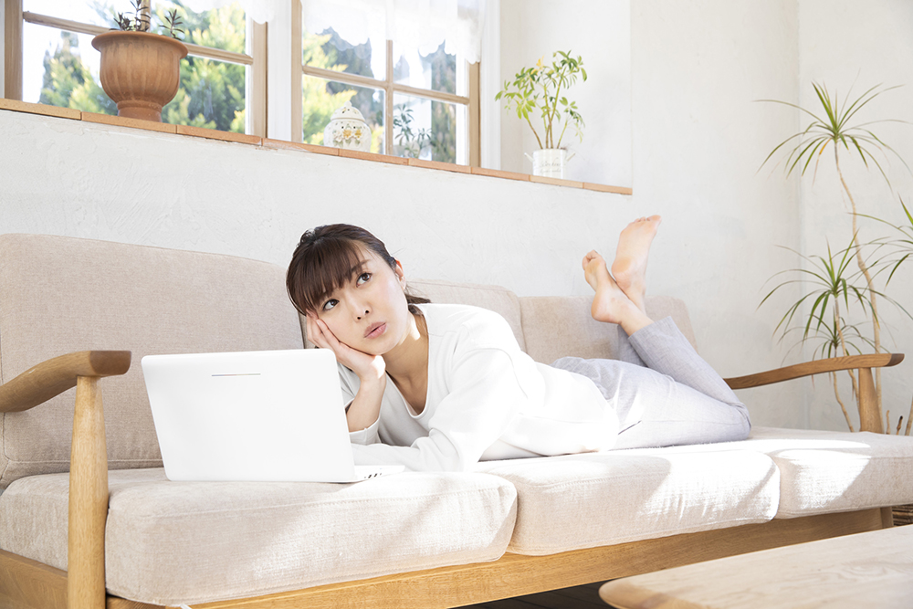 ひじ掛けが木製のソファで横になっている人の写真