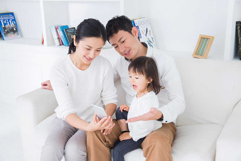 スマホでデータを共有する家族のイメージ写真