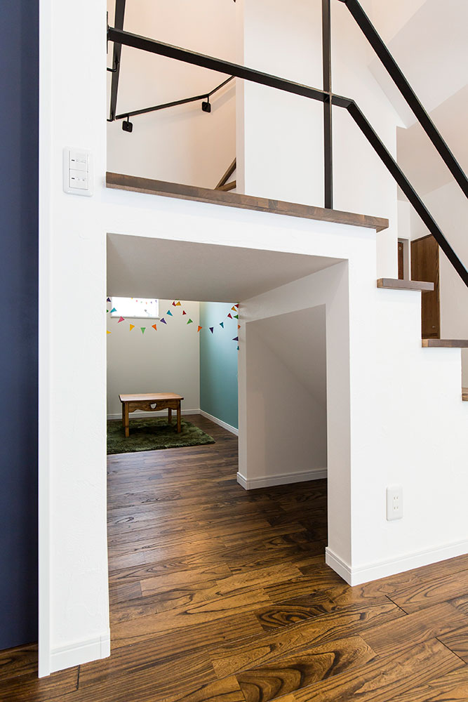 階段下にキッズスペースとゆるやかにつながるトンネルを設けた実例