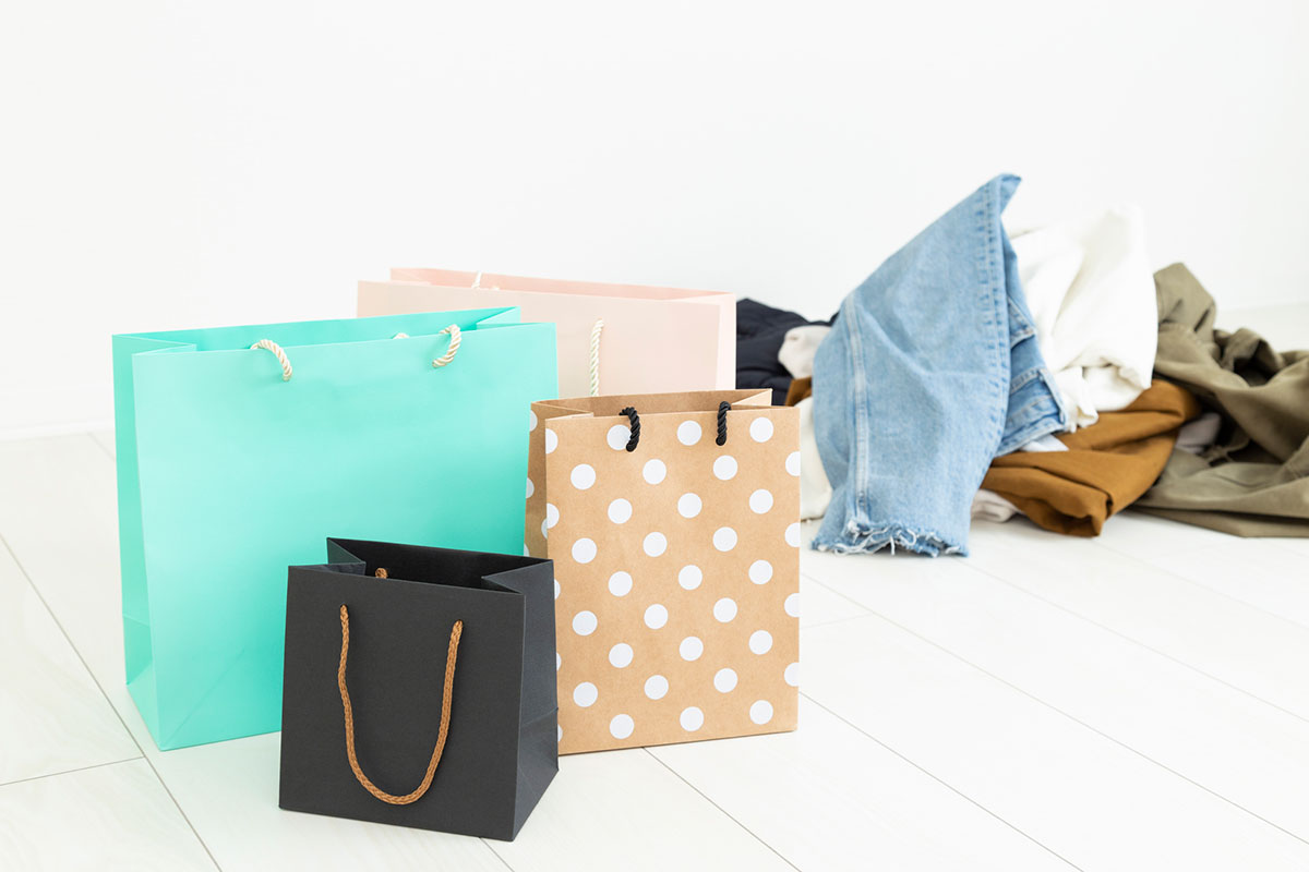 山積みの服と買い物袋