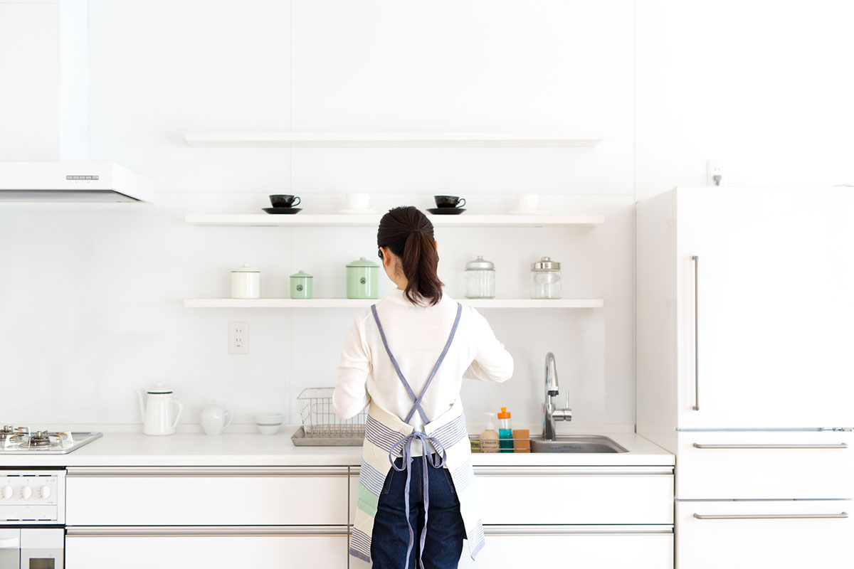 壁付けキッチンで作業する女性