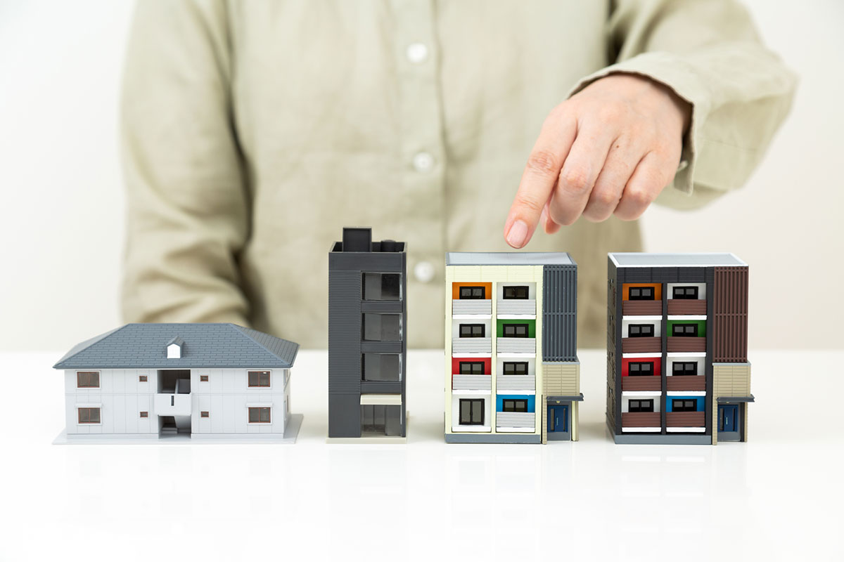 複数の賃貸物件を前にして、どこに住もうか悩む女性