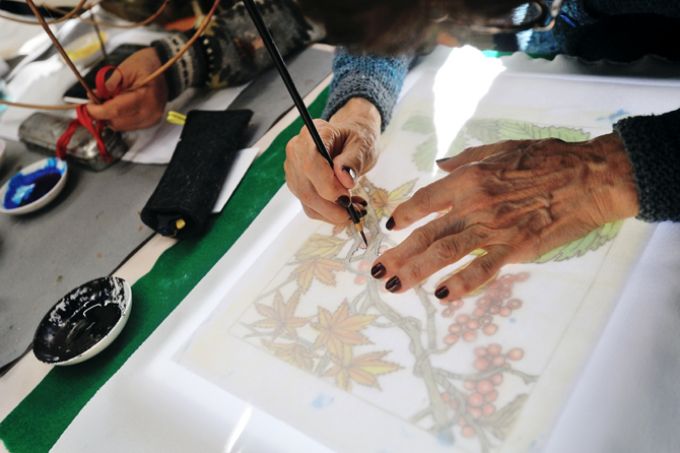 サンシティの染色クラブの活動の様子。図案を布地に写しているところ