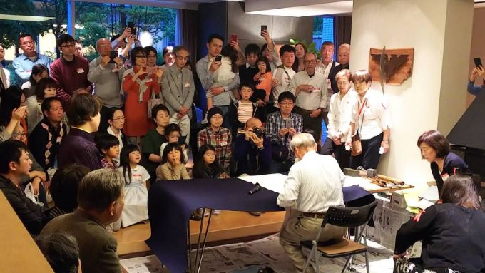 書道家である住人のパフォーマンスに集まる人々