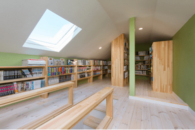 天井いっぱいの書棚と壁際にもびっしり書棚を造作した小屋裏のライブラリーの写真
