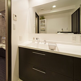 空間に広がりを感じさせる大きな鏡と大人っぽいテイストの洗面室