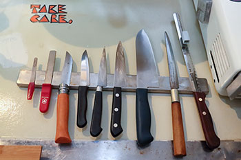 マグネットの棒を金具で壁に留めて包丁を密着。洋食店ではお馴染みのスタイルだそう。左上の