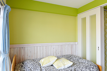 スライド扉で仕切ることもできるベッドルーム。寝覚めの目にも優しいグリーンのクロスを使用している