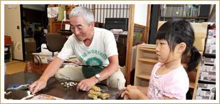 祖父と孫ほど年の離れた2人が粘土細工で遊ぶ。今後はこうした世代間の交流を活発化させるべく、地域の高齢者にも声をかけているという